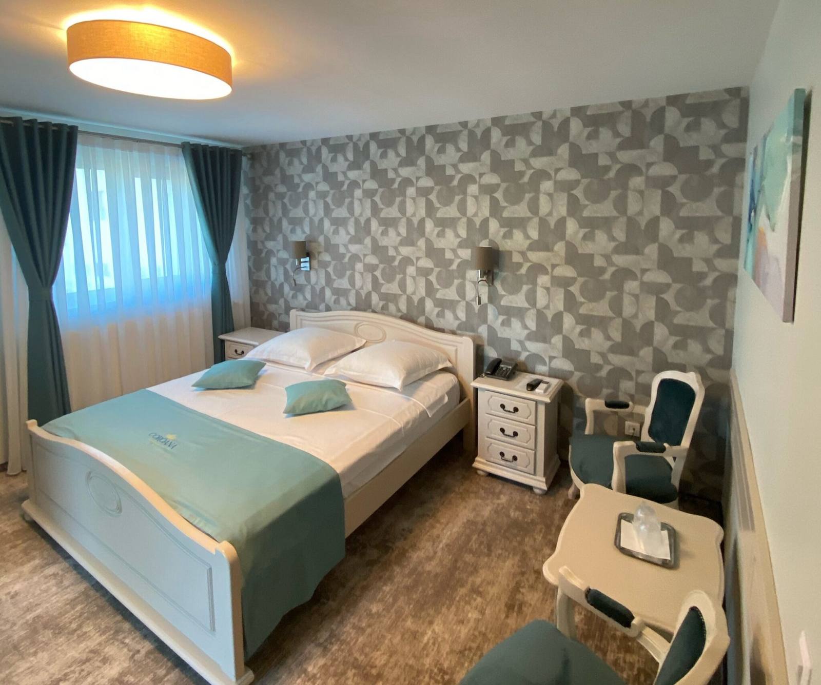Cameră renovată — colț de relaxare cu fotoliu și tapet decorativ