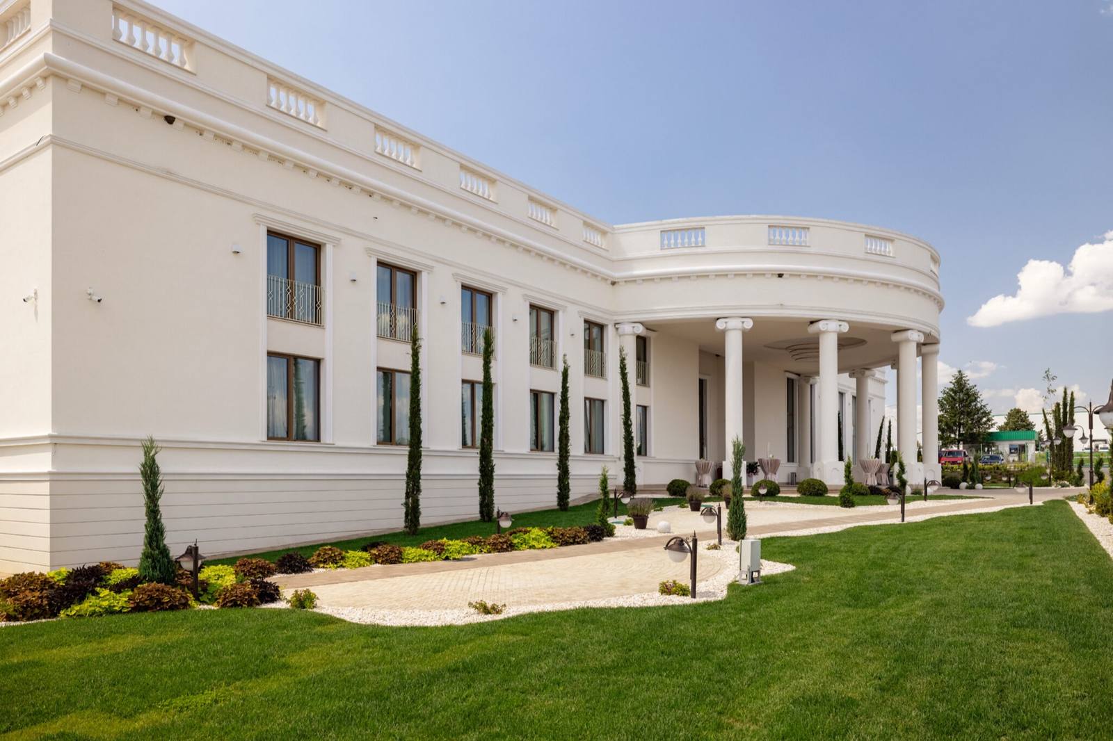 Fațada albă a domeniului Coroana Events, cu colonade